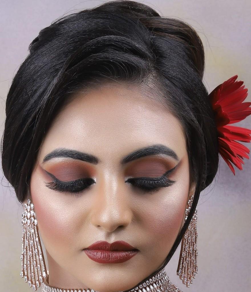 Close-up beauty look with winged eyes and red floral hair detail by Nensi